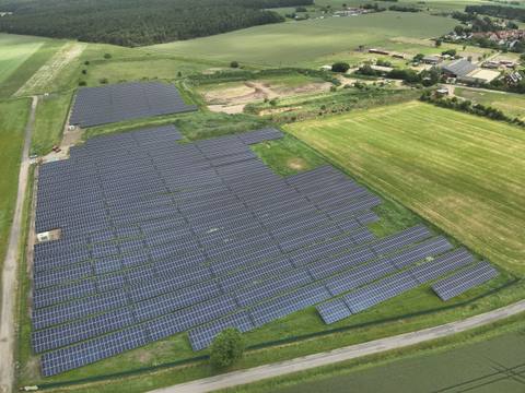 Luftbild einer Freiflächen-Photovoltaikanlage zwischen Feldern und Wegen