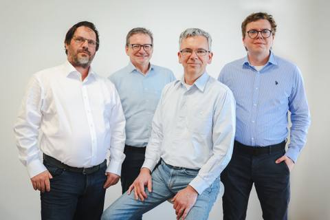 Vier Sachverständige der SONNWINN GmbH in hellen Hemden vor einer weißen Wand