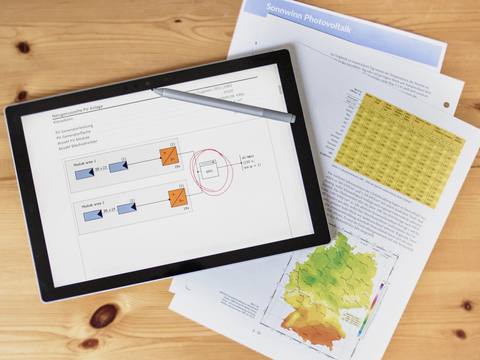 Tablet mit dem Schaltbild einer PV-Anlage auf Gutachtenseiten mit Einstrahlungskarte und Tabellen