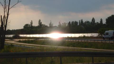 Reflexion des Sonnenlichts an einer Photovoltaikanlage neben einer Straße