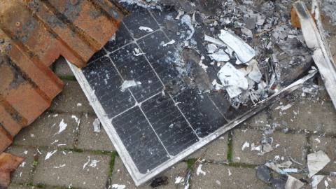 Durch Brand beschädigtes PV-Modul zwischen Trümmern auf dem Boden