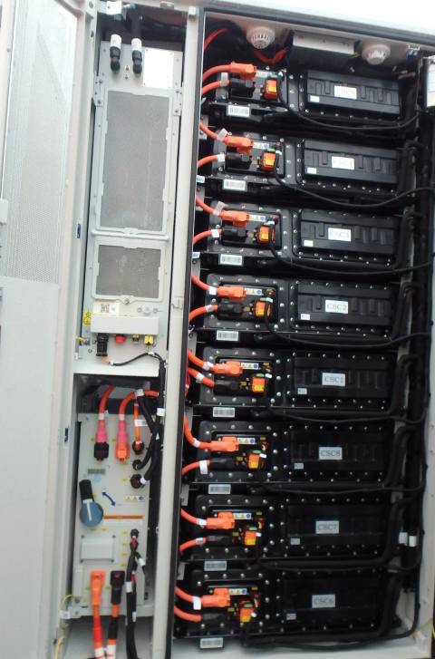Geöffneter Batterieschrank eines Speichersystems mit gestapelten Batteriemodulen und Leistungsanschlüssen