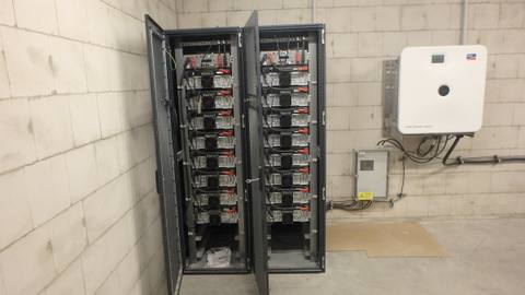 Geöffnete Batterieschränke mit gestapelten Batteriemodulen in einem Technikraum