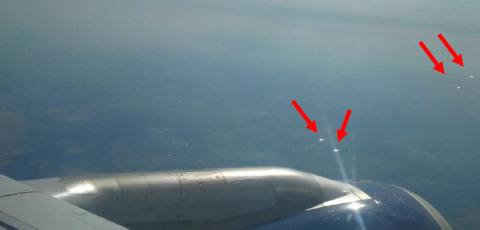 Blick aus einem Flugzeugfenster auf Reflexionen von Photovoltaikanlagen am Boden